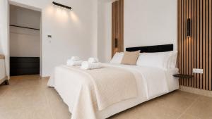 a bedroom with a large white bed with two stuffed animals on it at Zalazak in Bobovišća
