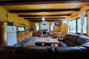 a living room with a leather couch and a table at Czirják Kulcsosház in Bucsin +22 photos