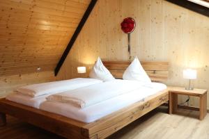 a bed in a room with a wooden wall at Roserhof Gengenbach in Gengenbach