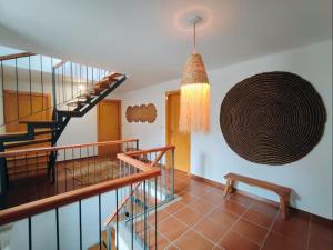 a hallway with a spiral staircase and a large artwork on the wall at Casa dos Côtos. in Castro Laboreiro