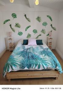 a bedroom with a bed with green leaves on the wall at La Casa de Nona in Carcassonne