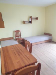 a room with two beds and a table and chairs at Zagajnik in Dębki