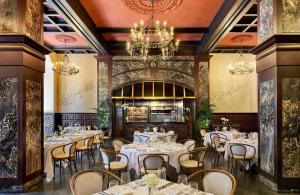 a dining room with tables and chairs and a chandelier at Omni Royal Orleans Hotel in New Orleans