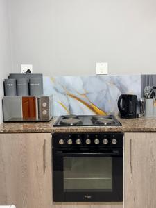 a kitchen with a stove and a microwave at Ekukhanyeni Guest house in Kwaluseni