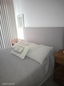 a bed with white sheets and a pillow on it at Monoambiente céntrico Sara in Gualeguaychú