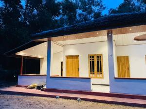 a small white house with two doors at Lotus Green Hotel And Restaurant in Arugam Bay