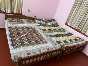 a bed with a quilt on it in a room at Kalliyattu Homestay in Palakkad