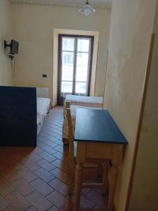 a room with a table and a room with two beds at La Casa dei Nonni in Berceto