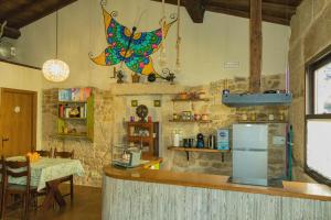 a kitchen with a counter with a table and a refrigerator at Casiñas De Acevedo in Junquera de Ambía