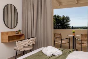 a bedroom with a bed and a table and chairs at Noma Vasilikos in Vasilikos +69 photos