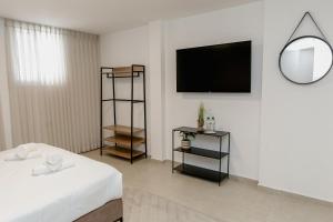 a room with a bed and a tv on a wall at Ramon Palms in Mitzpe Ramon