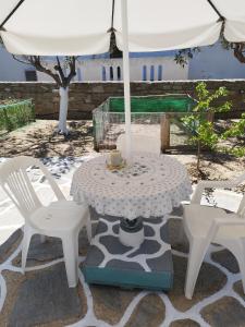 a table and two chairs and an umbrella on a patio at Iro's Cute House in Parikia