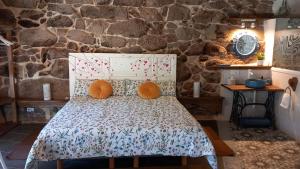 a bed in a room with a stone wall at Casiñas De Acevedo in Junquera de Ambía +51 photos