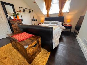 a bedroom with a large bed with a black leather couch at Chip's House in Pennyburn +17 photos