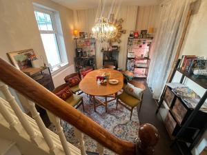 a living room with a table and chairs and a chandelier at Chip's House in Pennyburn