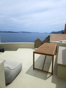 a patio with a table and chairs on a balcony at Phaos Oia Suites in Oia
