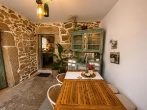 a table and chairs in a room with a stone wall at Holibai Mirada do Roxo 3 suites y vistas al mar in Oia +24 photos