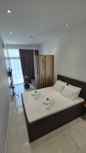 a bedroom with a large white bed with towels on it at fenias luxury studios in Kallithea Halkidikis +38 photos