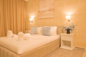 a bedroom with a bed with white pillows at Villa Joanna in Xagħra +32 photos