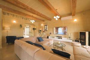 a large living room with a couch and a tv at Villa Joanna in Xagħra