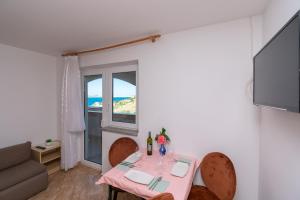 a small living room with a table and a window at Apartments PoolHouse in Metajna