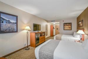a hotel room with two beds and a television at C'mon Inn Missoula in Missoula