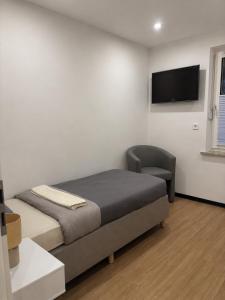 ein Schlafzimmer mit Bett, Stuhl und Flachbildfernseher in der Unterkunft WeserZeit Apartment in Bodenwerder