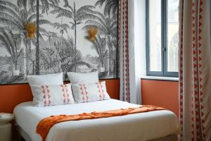 a bedroom with a bed with a tropical wallpaper at ARBELLIA Appart'Hôtel Châlons en Champagne in Chalons en Champagne +13 photos