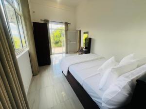 a bedroom with two beds and a window at Emerald Leaf Kandy Villa in Panabokka