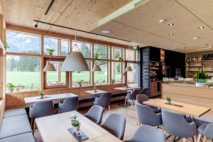 a restaurant with tables and chairs and windows at Boutique Hotel LechZeit in Elmen