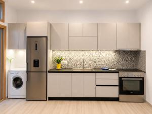 a kitchen with white cabinets and a refrigerator at G&D guest house in Ancient Epidauros