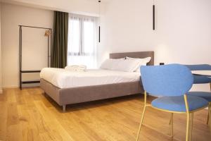 a bedroom with a bed and two blue chairs at Solemar Sicilia - Torre Maqueda in Palermo