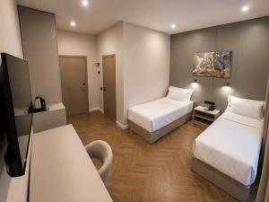 a hotel room with two beds and a television at Delmont hotel in Kostanay +32 photos