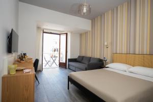 a hotel room with a bed and a couch at Garibaldi Suite B&B in Salerno