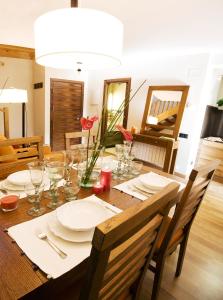 una mesa de comedor con platos y vasos. en Apartaments Petit Saüc, en Taüll
