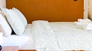 a bed with white pillows and towels on it at Apartmani Tika in Golubac