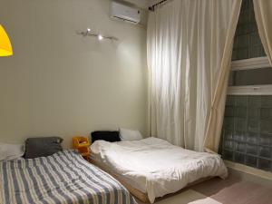 a bedroom with two beds and a window at Anhbnb in Danang