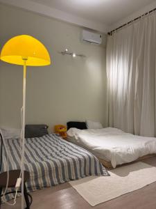 a bedroom with two beds and a yellow lamp at Anhbnb in Danang