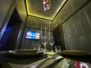 a table with two wine glasses and a tv at La Suite Pisa in Pisa