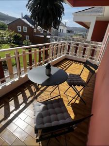 a balcony with a table and chairs and a table at Villa Neli Playa in Foz