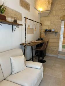 a living room with a white couch and a desk at AvVolta nel Salento - Room & Relax in Torchiarolo