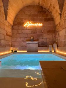 a swimming pool in a stone building with an indoor swimming pool at AvVolta nel Salento - Room & Relax in Torchiarolo