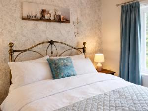 a bedroom with a white bed with a blue pillow at Afan Forest Retreat Bikes, Pets, Family,Workers in Cymmer