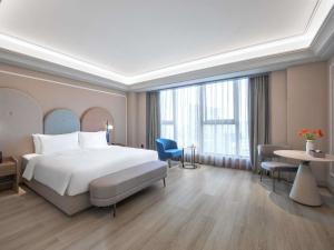 a hotel room with a bed and a large window at Mercure Chengdu Dongjiao Memory in Chengdu +67 photos