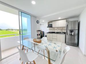 a kitchen and dining room with a glass table and white chairs at Mirador, Coveñas 302 in Coveñas