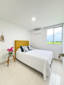 a white bedroom with a bed and a glass table at Mirador, Coveñas 302 in Coveñas +62 photos