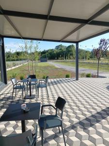 a patio with tables and chairs under a tent at LakeSide Camping in Koplik