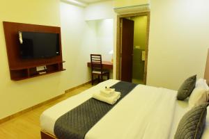 a bedroom with a large bed with a tv on the wall at The Marwar regency Hotel in Jodhpur +7 photos
