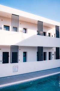 an external view of a building with a swimming pool at fenias luxury studios in Kallithea Halkidikis