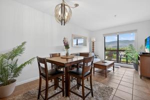 a dining room with a table and chairs with a view at Playa Del Sol 2 Bdrm 649 w/ Mountain Views! in Kelowna